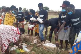 Volunteers and residents distributing support items during a community outreach activity.