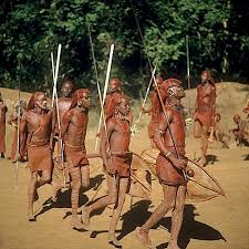 Community members walking together in traditional dress during a cultural gathering.